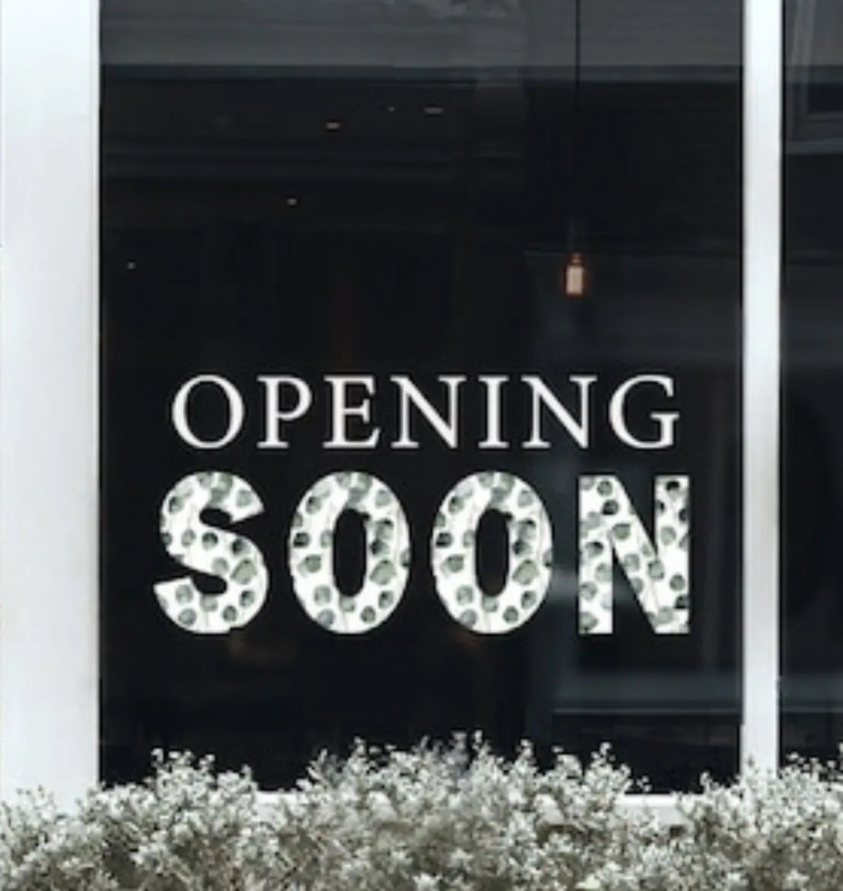 An “opening soon” sign in a downtown window