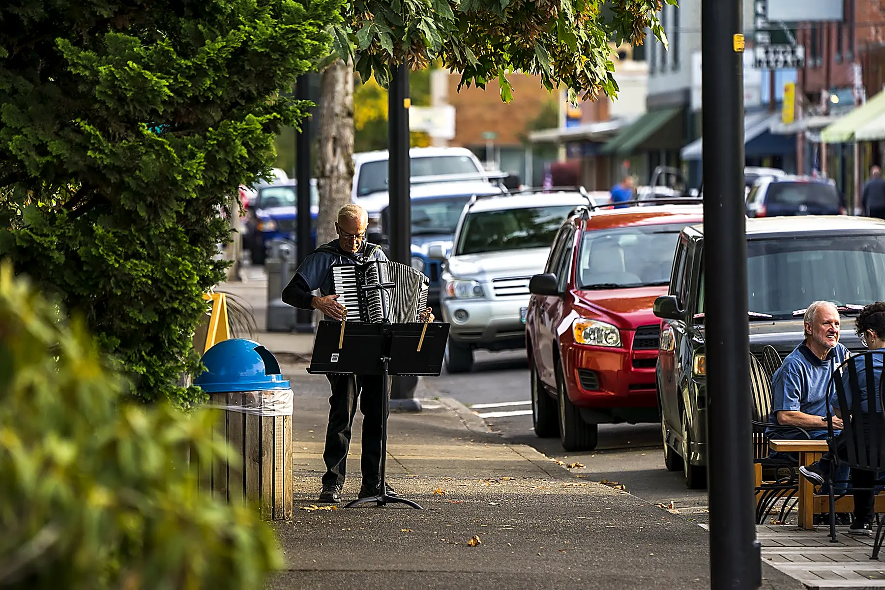 A musician playing the accordion on a downtown Stayton sidewalk